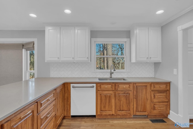 kitchen featuring light wood-style flooring, dishwasher, white cabinetry, and a sink