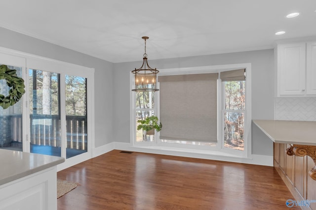 unfurnished dining area with recessed lighting, visible vents, a healthy amount of sunlight, and wood finished floors