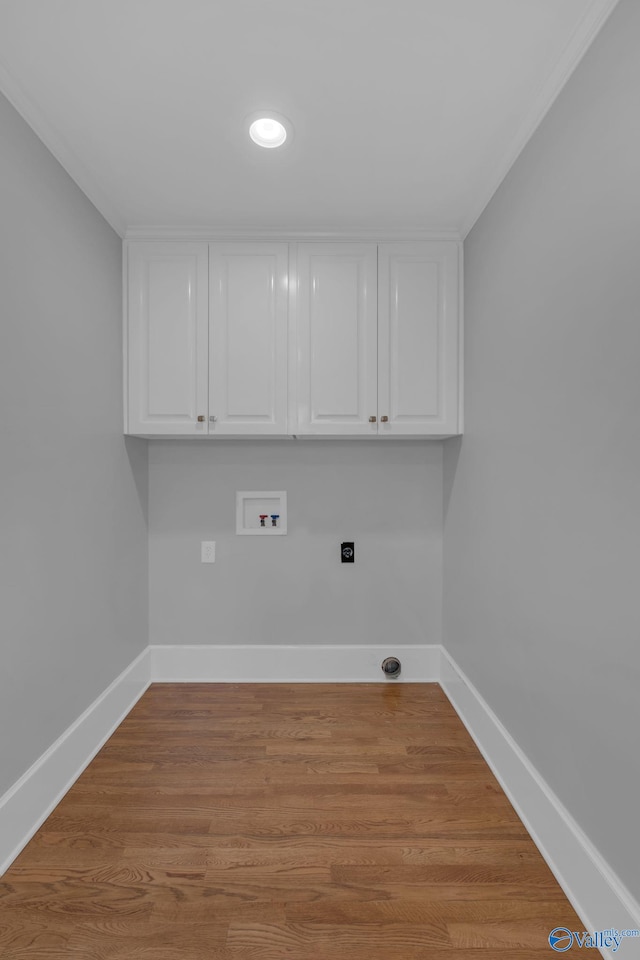 washroom featuring cabinet space, light wood-style flooring, baseboards, and washer hookup