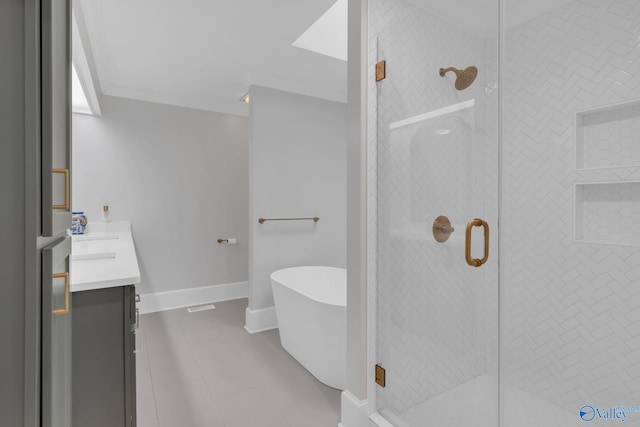 bathroom with crown molding, baseboards, a stall shower, a freestanding tub, and vanity