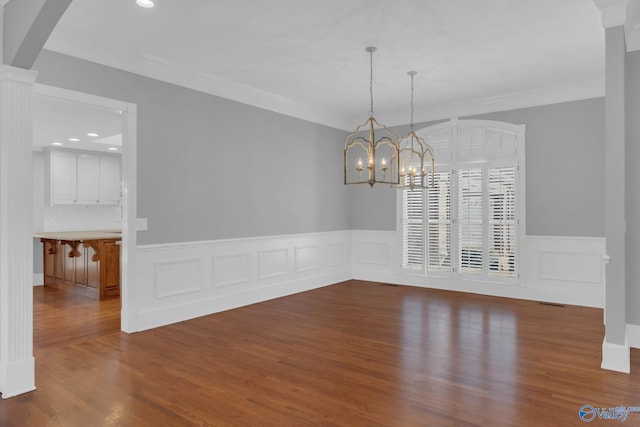 unfurnished dining area with dark wood-style floors, arched walkways, a notable chandelier, and ornamental molding