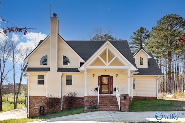 view of front of house featuring brick siding, covered porch, roof with shingles, and a chimney