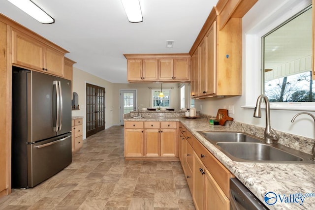 kitchen featuring a sink, stainless steel appliances, a peninsula, and light brown cabinetry