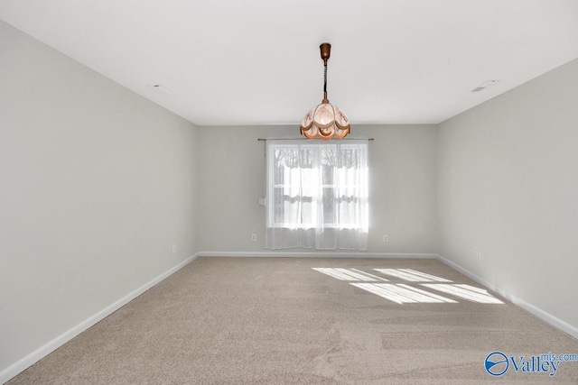 spare room featuring baseboards and carpet floors