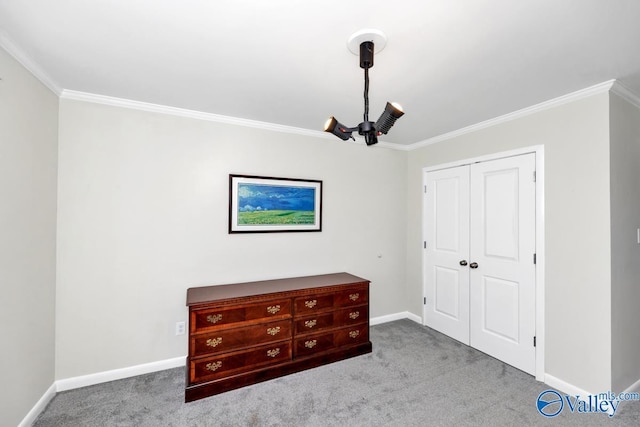 unfurnished bedroom with a closet, carpet floors, baseboards, and crown molding