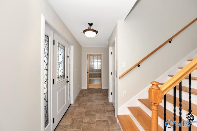 entrance foyer with stairway and baseboards