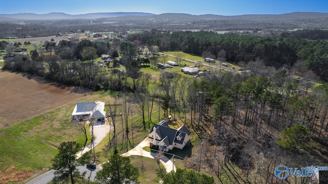 birds eye view of property with a mountain view and a forest view