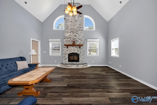 living room with a wealth of natural light, visible vents, a stone fireplace, and wood finished floors