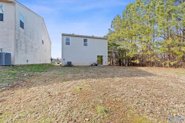 back of property featuring a lawn and central AC