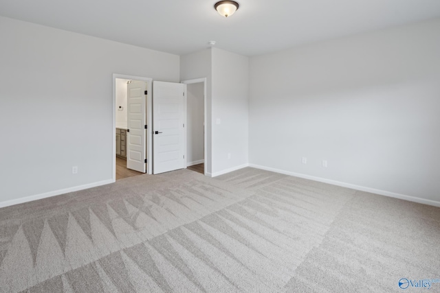 unfurnished room featuring light carpet