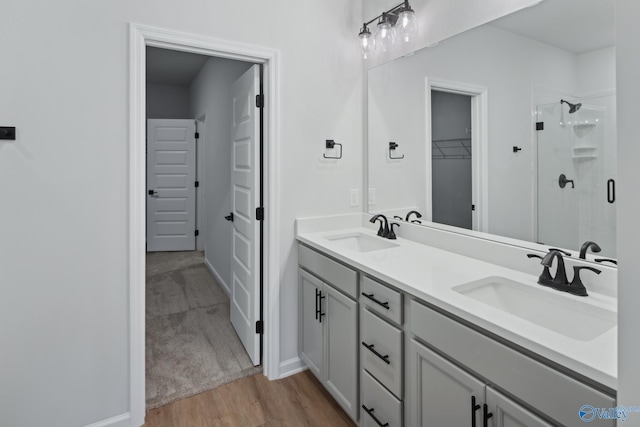 bathroom with hardwood / wood-style floors, vanity, and a shower with shower door