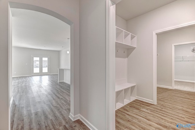 mudroom with french doors and light hardwood / wood-style floors