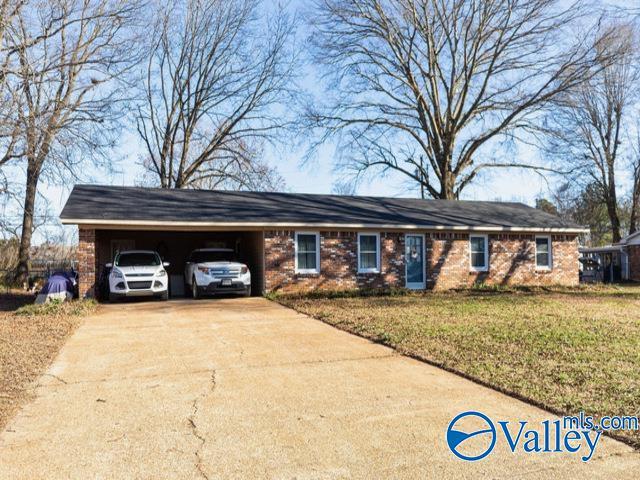 single story home with a front lawn and a carport