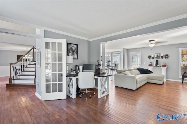 living room featuring ornamental molding, hardwood / wood-style floors, a textured ceiling, and decorative columns