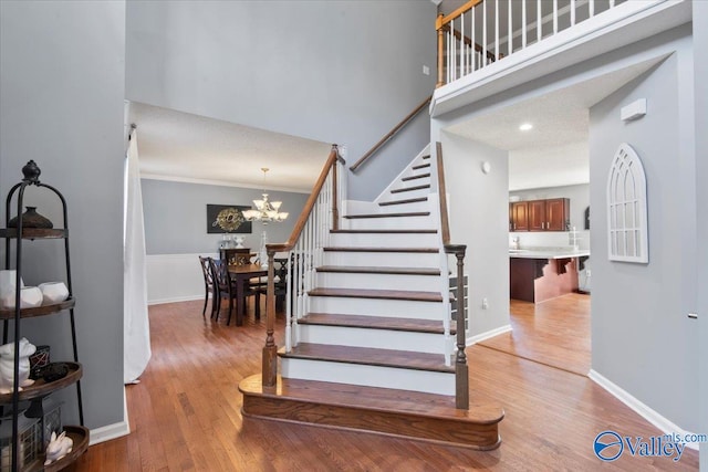 stairs featuring a notable chandelier and wood-type flooring