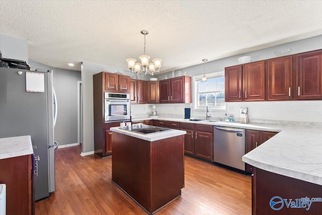 kitchen with pendant lighting, a center island, stainless steel appliances, and dark hardwood / wood-style floors