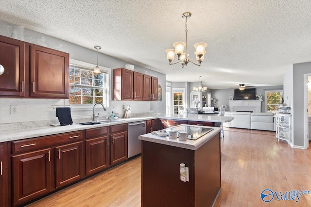 kitchen featuring dishwasher, sink, light wood-type flooring, and decorative light fixtures