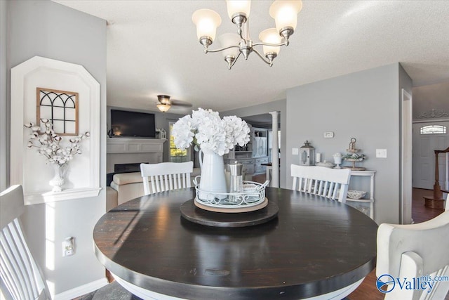 dining room with decorative columns, a textured ceiling, an inviting chandelier, and wood-type flooring