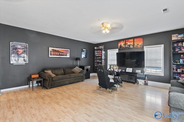 living room with ceiling fan and light hardwood / wood-style flooring