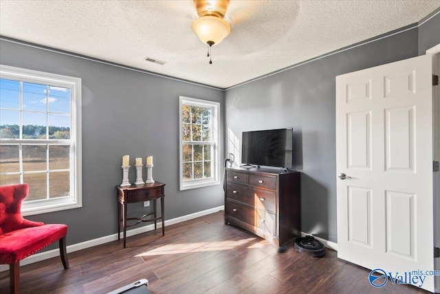 living area featuring ornamental molding, a textured ceiling, dark hardwood / wood-style floors, and ceiling fan