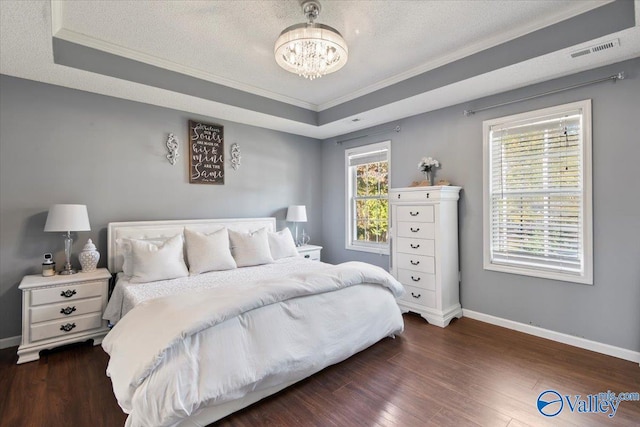 bedroom with a raised ceiling, a textured ceiling, crown molding, a chandelier, and dark hardwood / wood-style floors