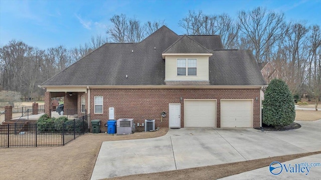 view of side of home with central AC unit and a garage