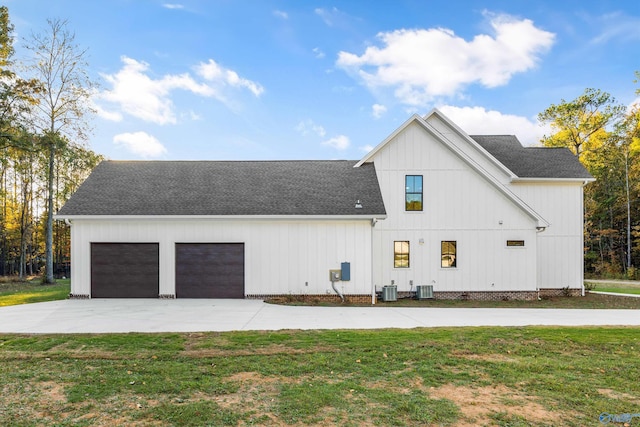 exterior space featuring a front yard, a garage, and central AC unit