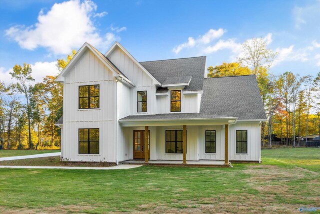 modern farmhouse style home with covered porch and a front lawn