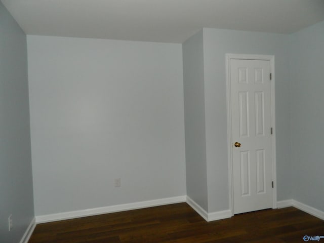 empty room with baseboards and wood finished floors