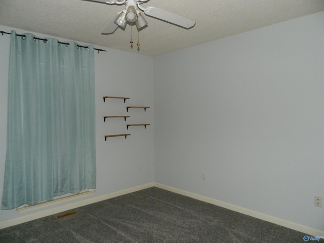 empty room with visible vents, baseboards, dark colored carpet, and a ceiling fan