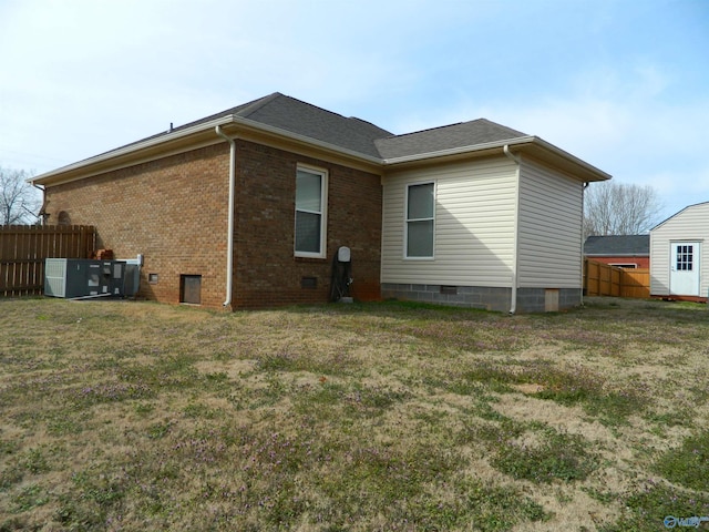 rear view of house featuring crawl space, brick siding, and fence