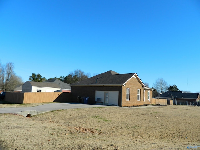 back of house with a yard, brick siding, and fence