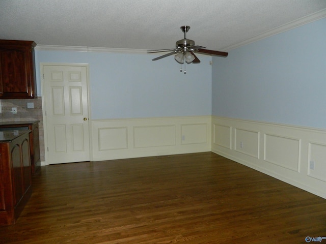 unfurnished dining area featuring ceiling fan, dark wood-style flooring, a textured ceiling, and crown molding