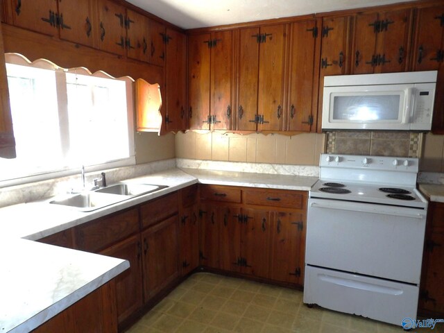 kitchen featuring white appliances, tasteful backsplash, and sink