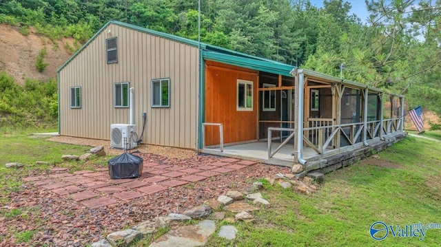 1228 Matt Morrow Rd, Arab, AL 35016 - rear view of house with a fire pit, a sunroom, a forest view, and a lawn