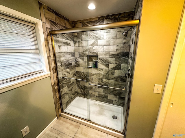 bathroom featuring baseboards, a stall shower, and tile patterned floors