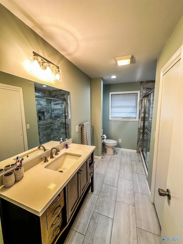 full bath featuring a stall shower, baseboards, vanity, and toilet