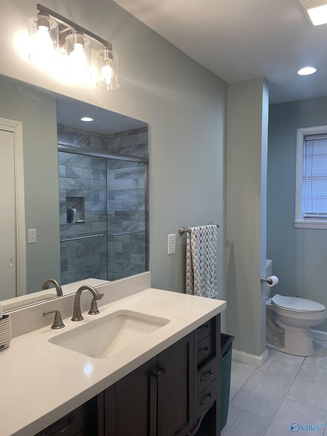 full bathroom featuring toilet, vanity, baseboards, a shower stall, and tile patterned floors