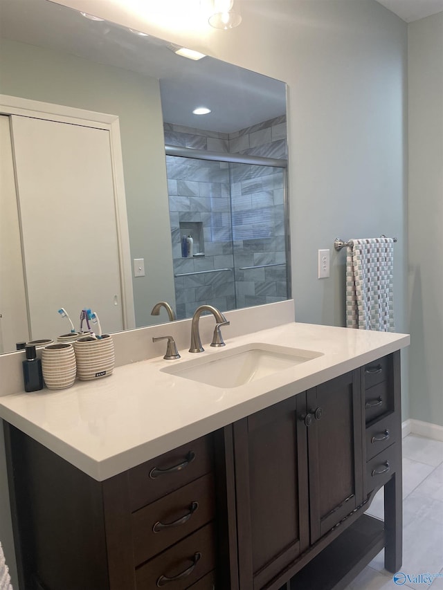 bathroom with baseboards, a shower stall, and vanity