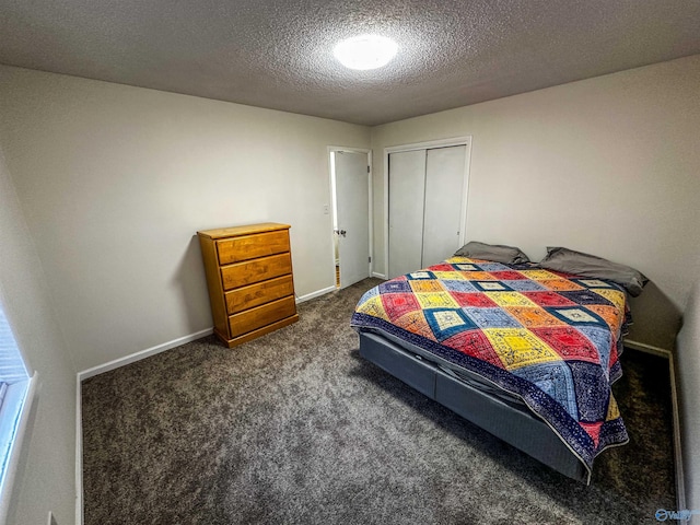 bedroom with a closet, dark carpet, a textured ceiling, and baseboards