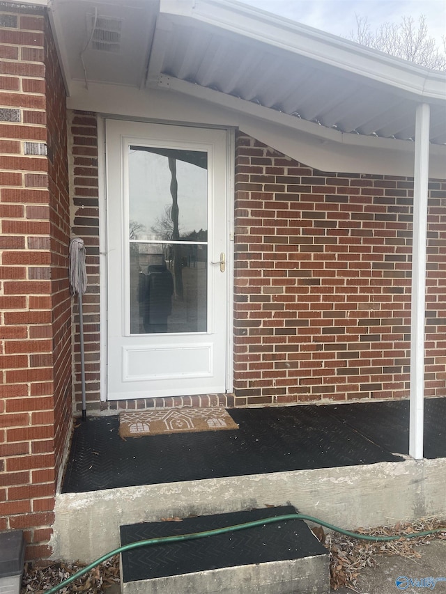 entrance to property featuring brick siding