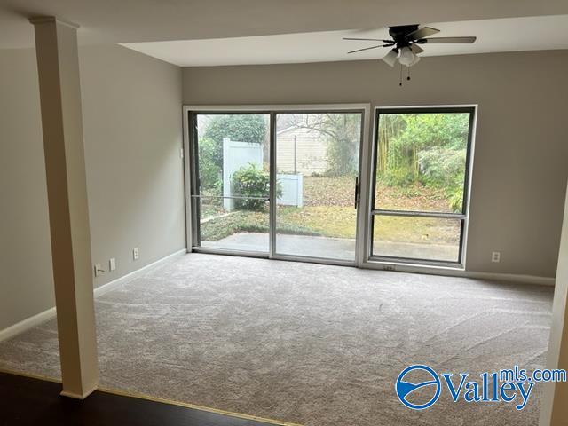 carpeted empty room with ceiling fan and baseboards