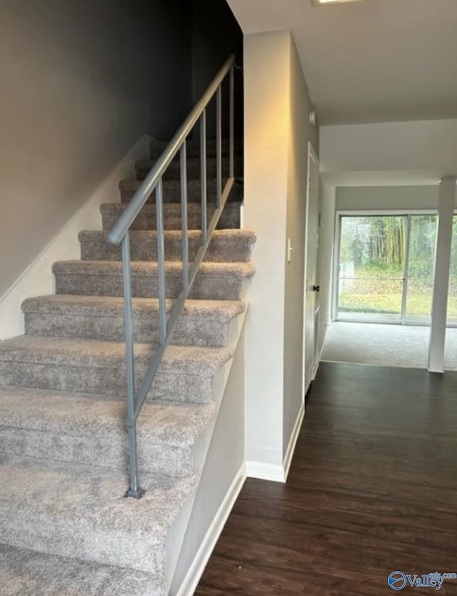 staircase with baseboards and wood finished floors