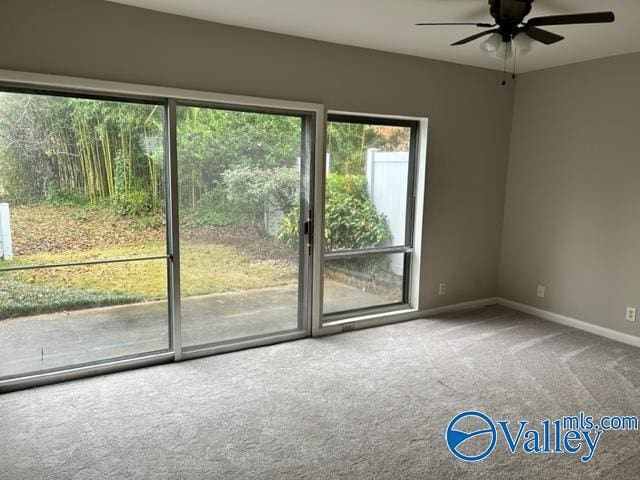 empty room featuring a ceiling fan, carpet flooring, and baseboards