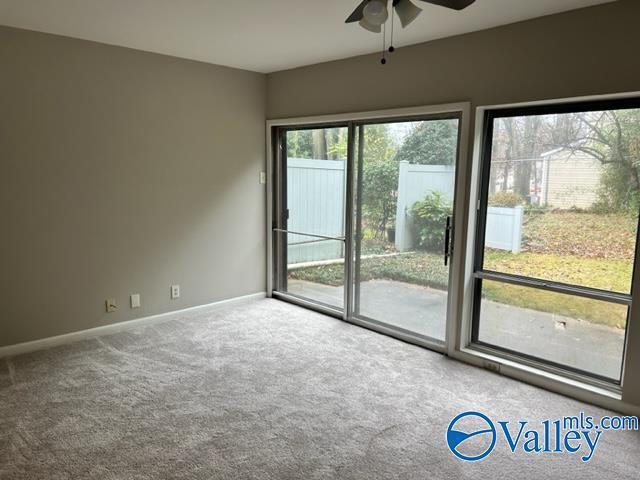 carpeted empty room featuring ceiling fan and baseboards