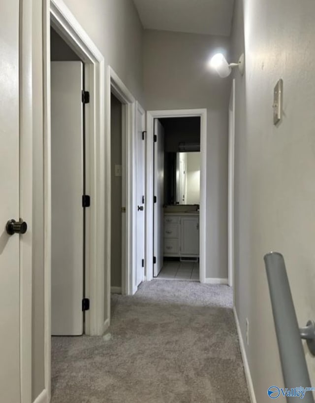 hall featuring carpet and baseboards