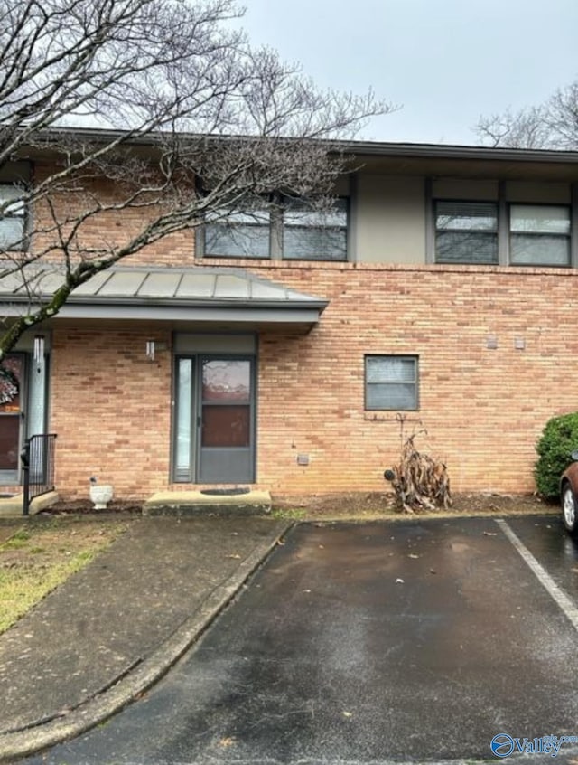 exterior space featuring uncovered parking and brick siding