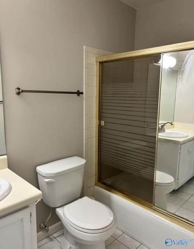 full bathroom featuring toilet, tile patterned flooring, bath / shower combo with glass door, and vanity