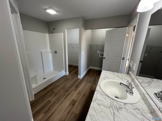 bathroom featuring vanity, a shower, and wood-type flooring