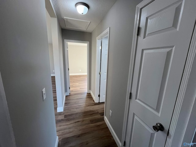 corridor with dark wood-type flooring and a textured ceiling